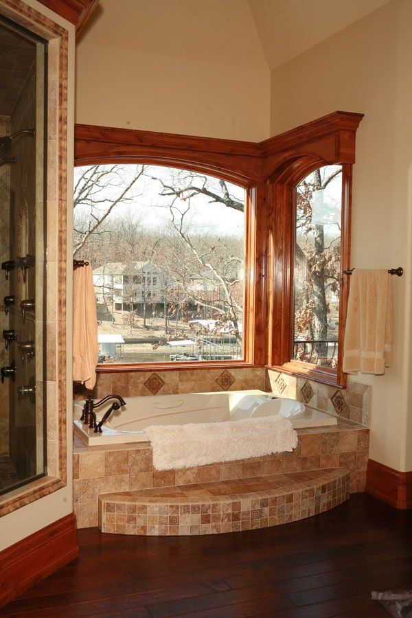 A bathtub in a bathroom with a large window