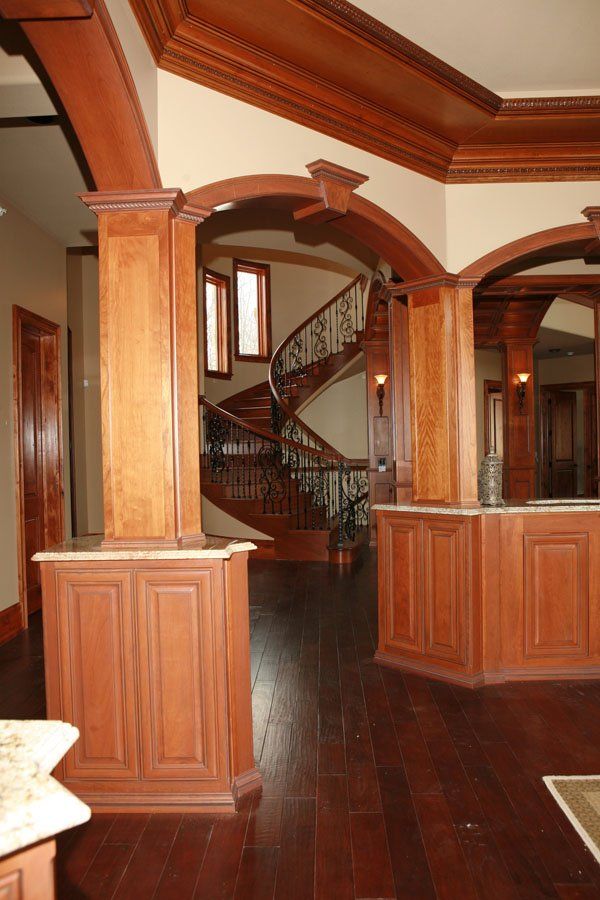 A staircase in a house with wooden columns and arches