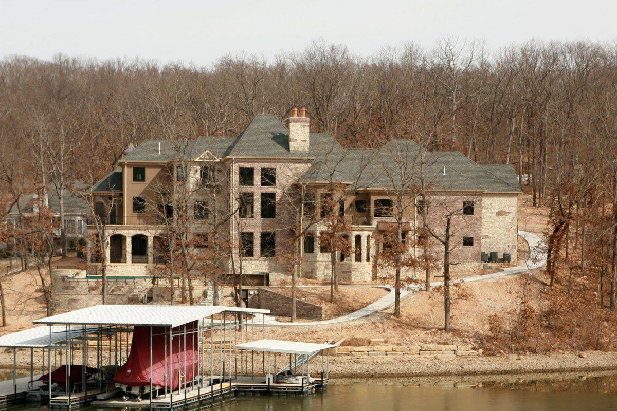 A large house with a boat docked in front of it