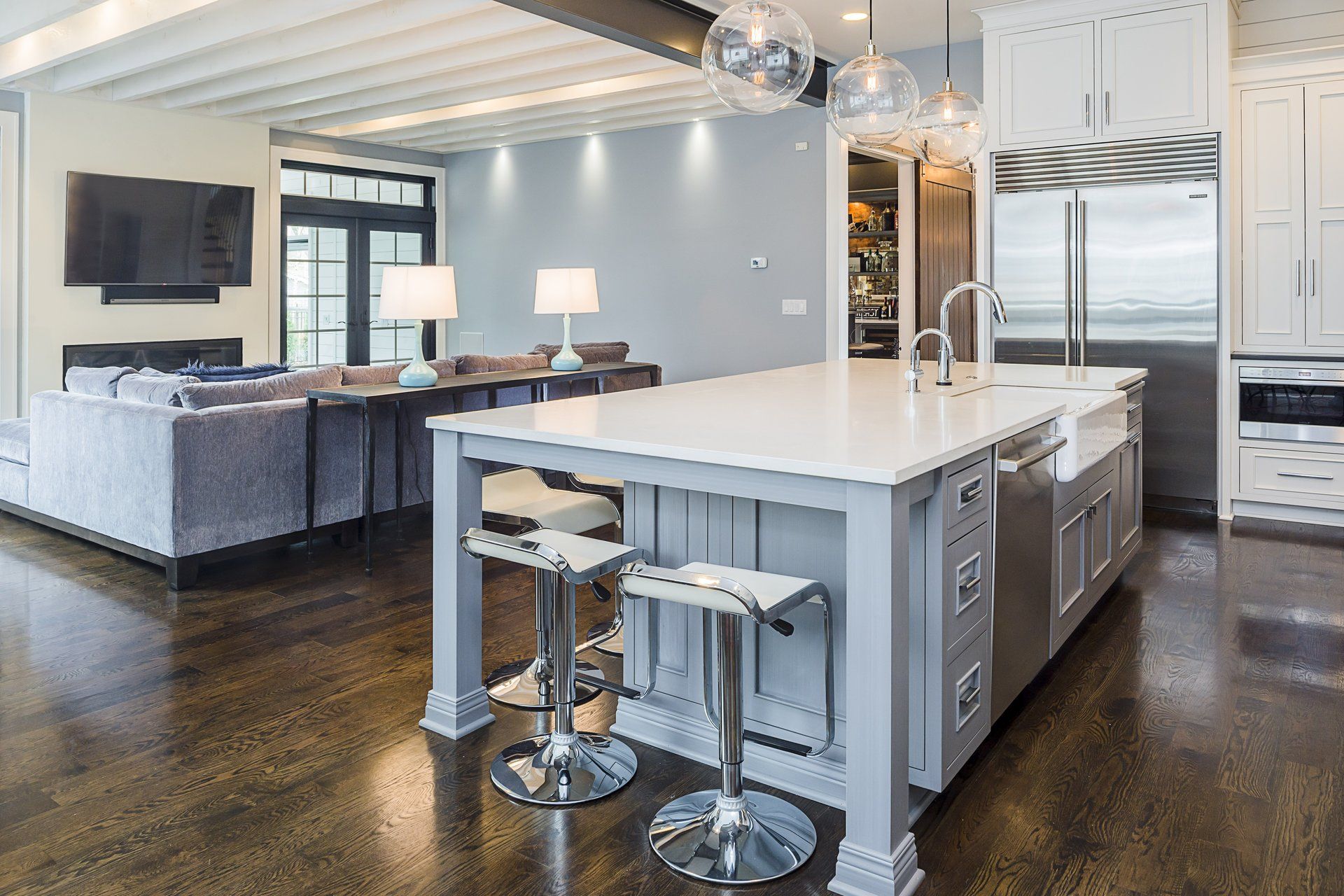 A kitchen with a large island in the middle of it and stools.