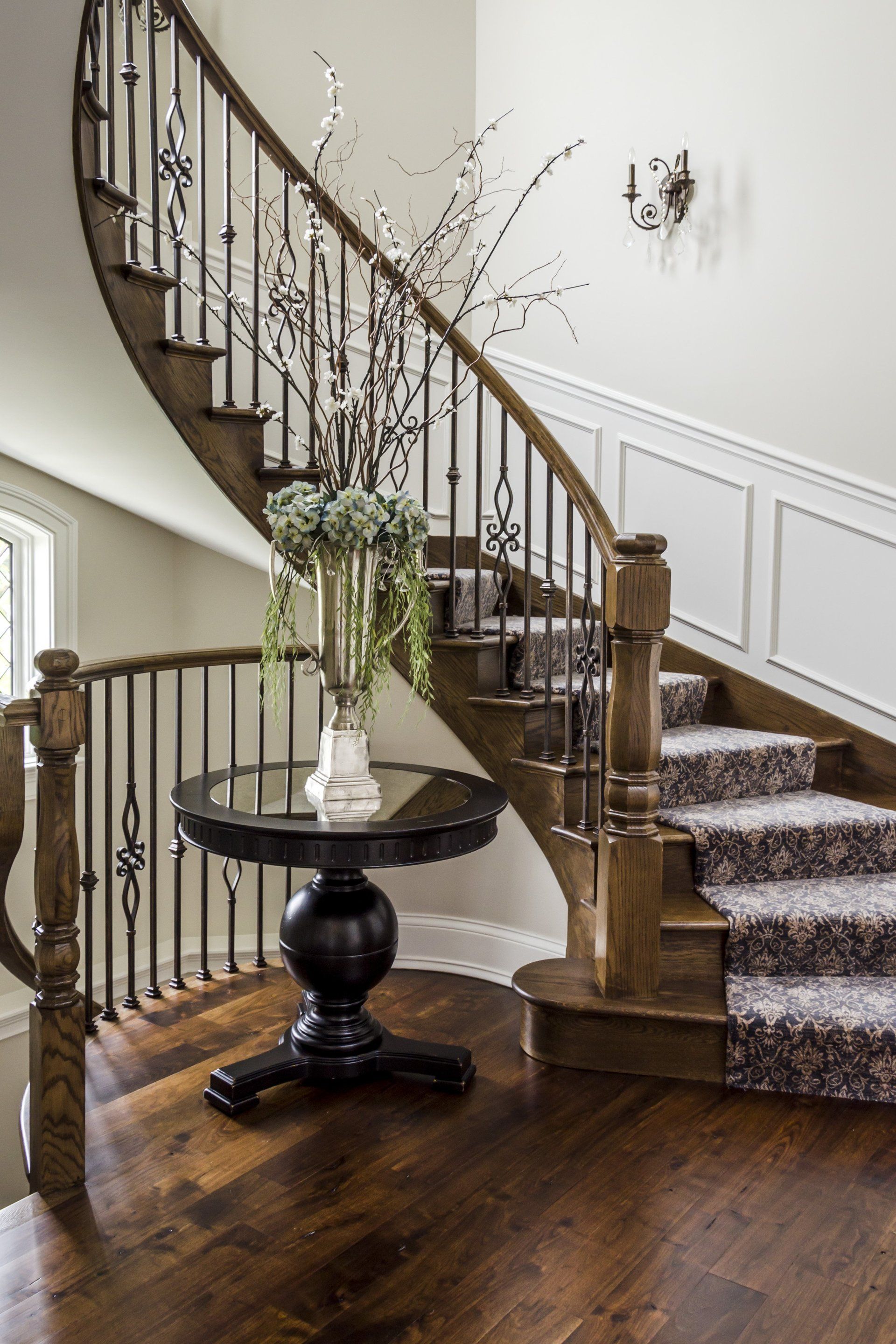 A wooden spiral staircase with a table in front of it.