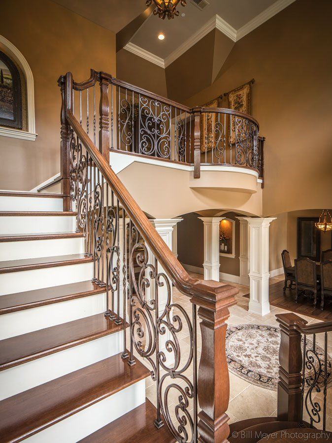A staircase in a house with a wrought iron railing