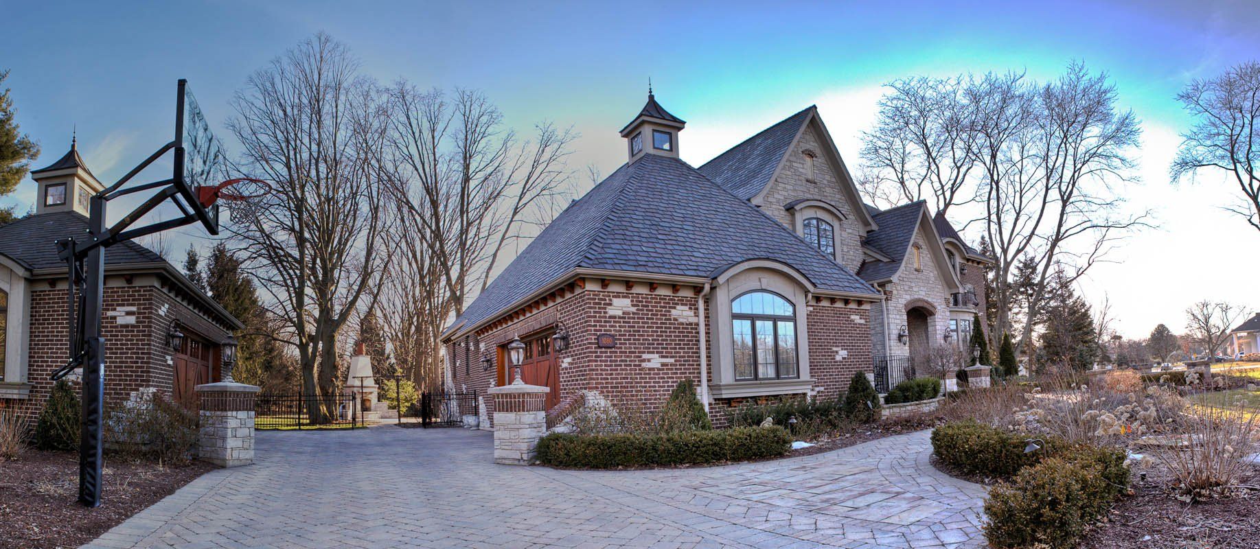 A large brick house with a basketball hoop in front of it.