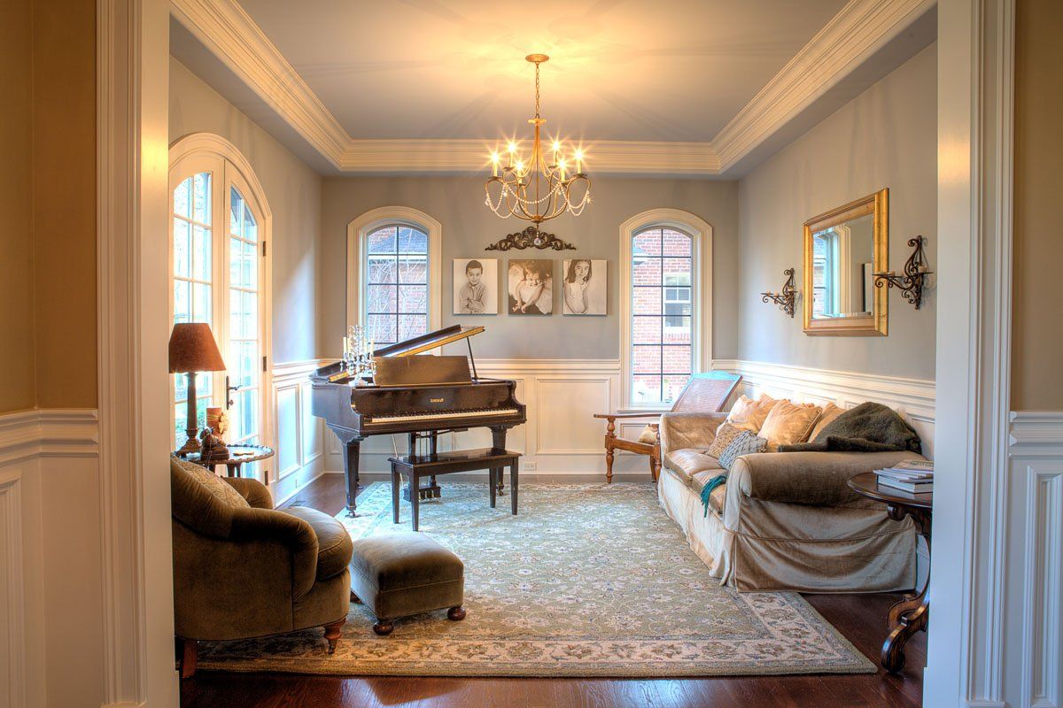 A living room with a piano and a chandelier