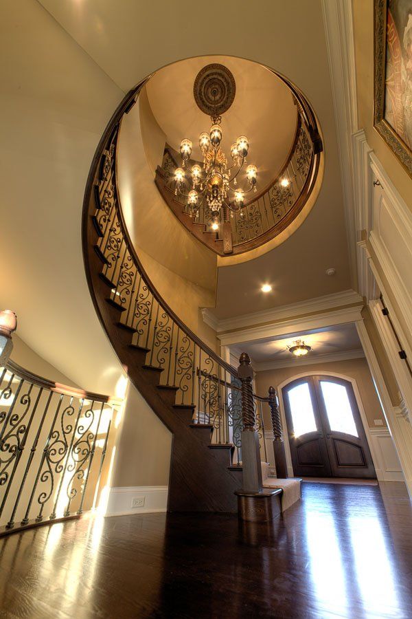A spiral staircase with a chandelier hanging from the ceiling