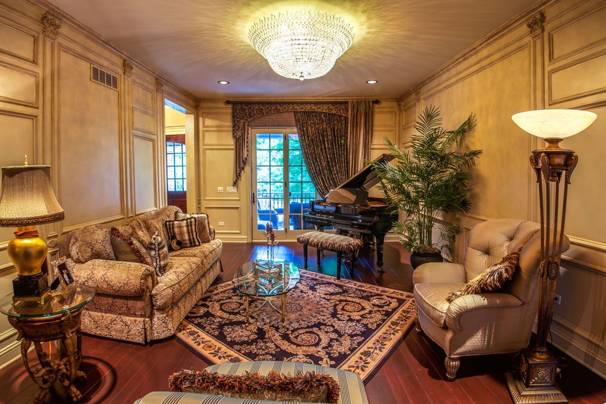 A living room with a couch , chair , lamp and piano.