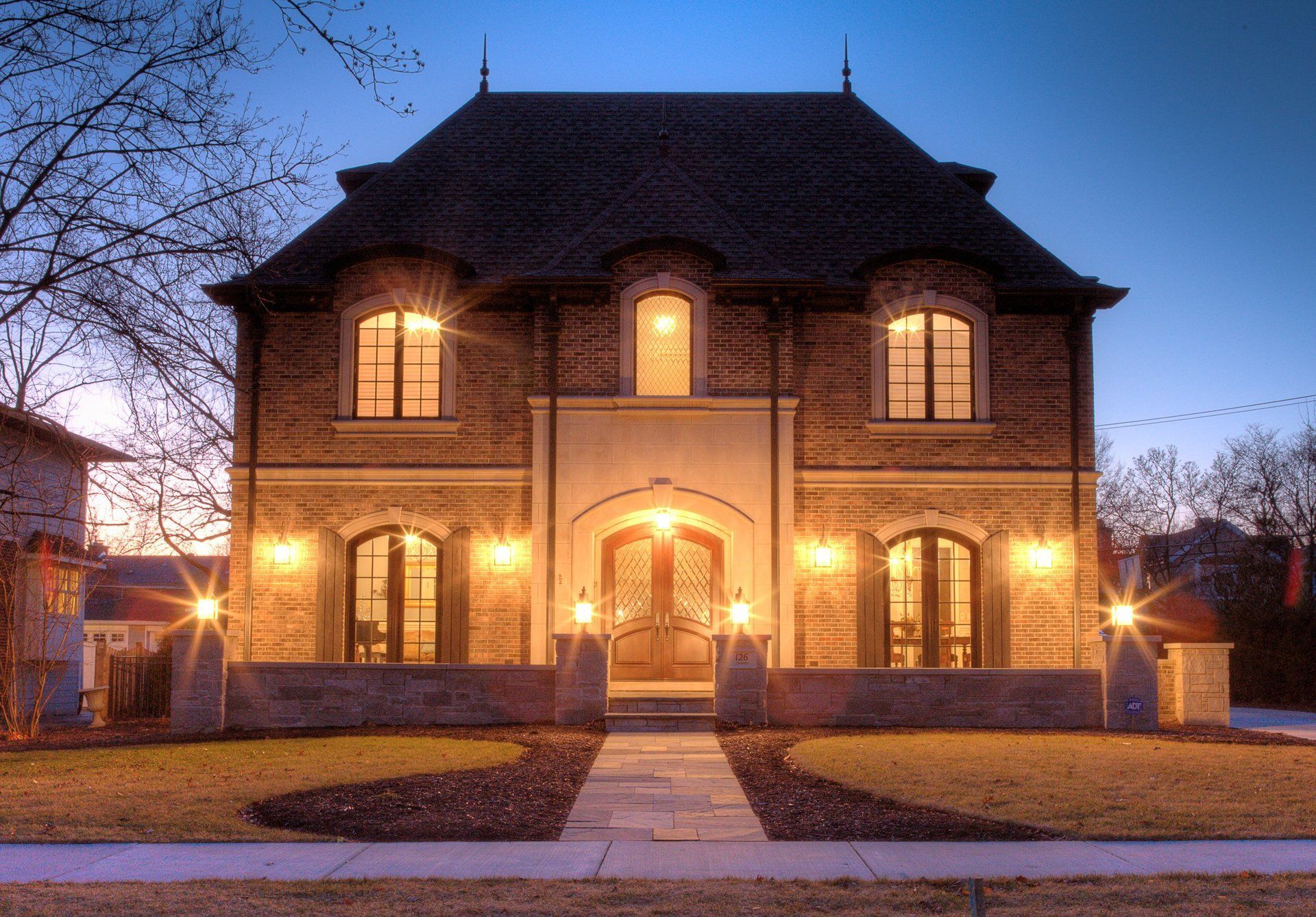A large brick house is lit up at night
