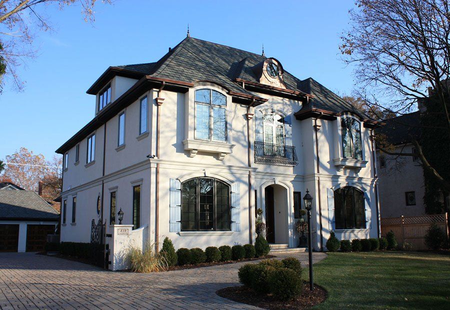 A large white house with a gray roof and a lot of windows