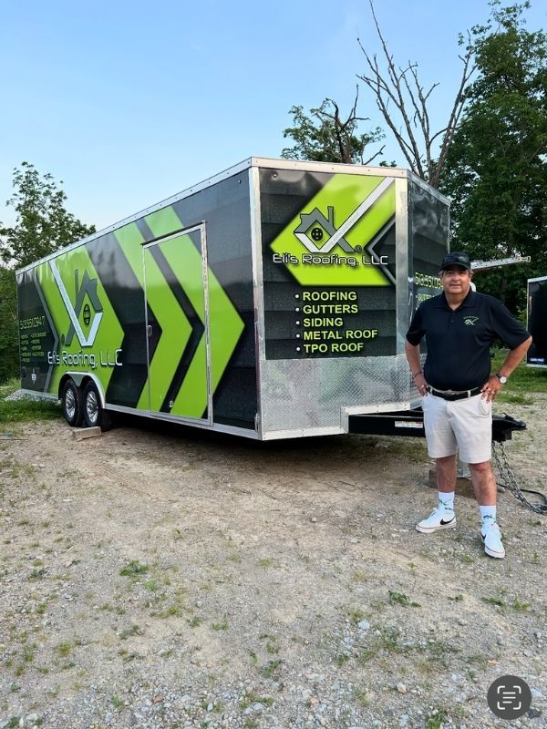 Eli next to trailer on-site at home roofing and repair service
