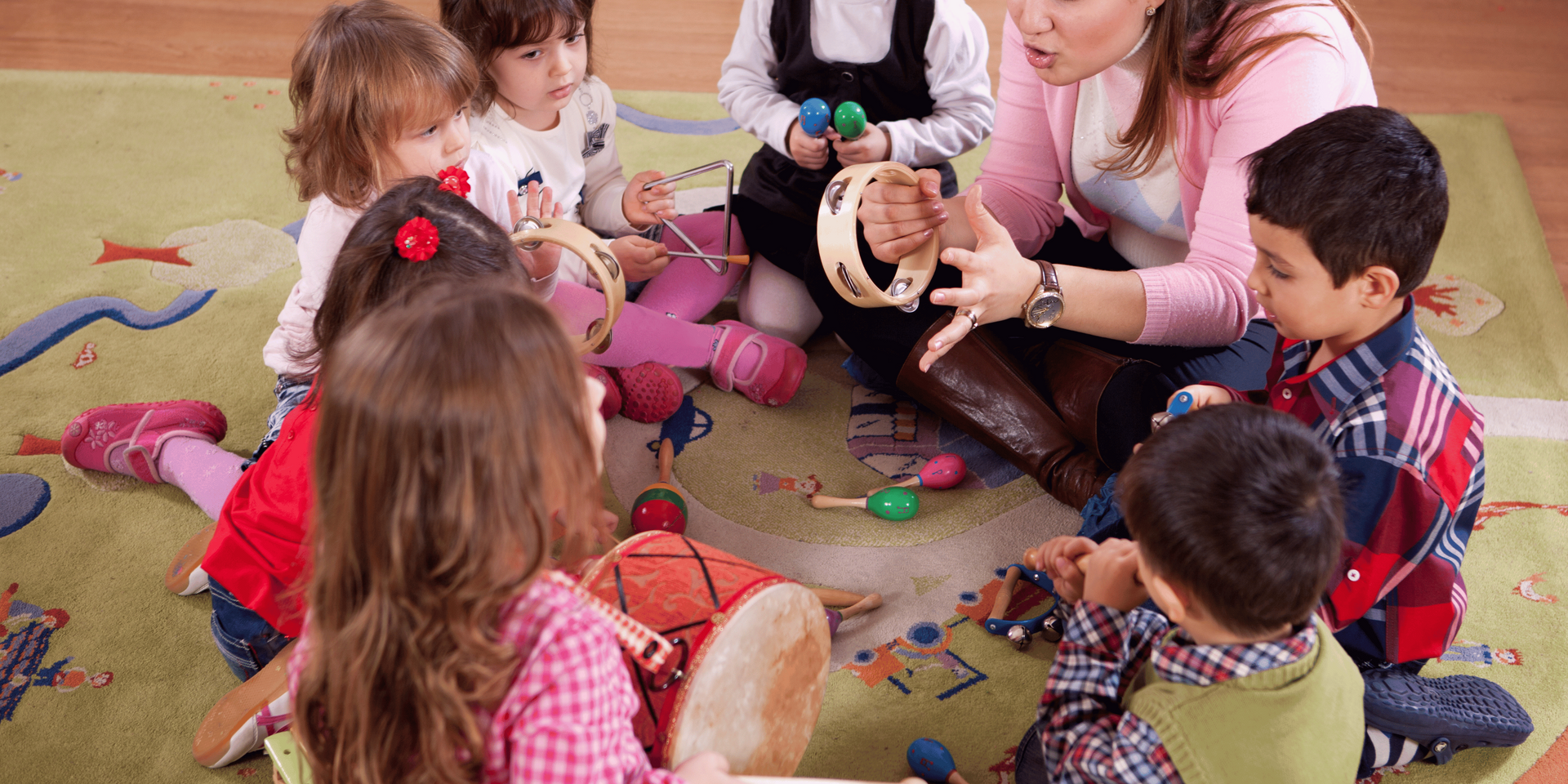 Three children are laying on the floor reading a book together.