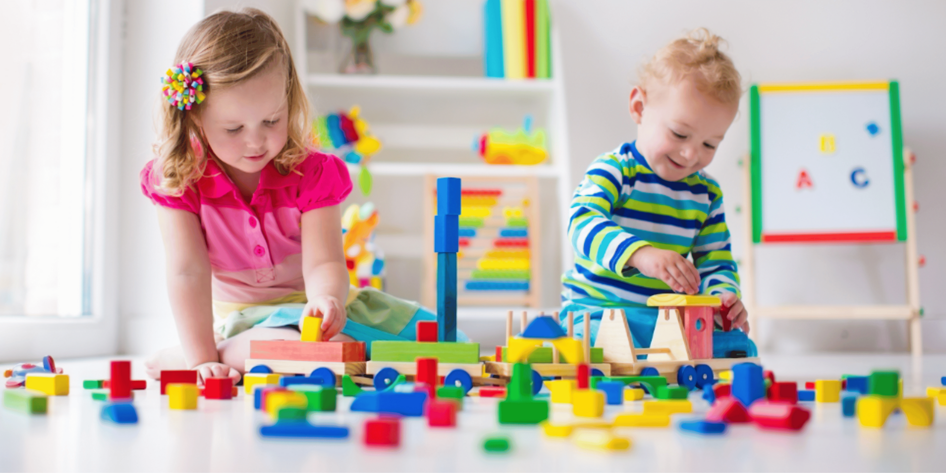 A group of children are sitting on the grass with a teacher.