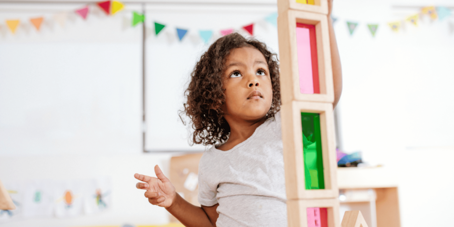 Three children are laying in a ball pit.