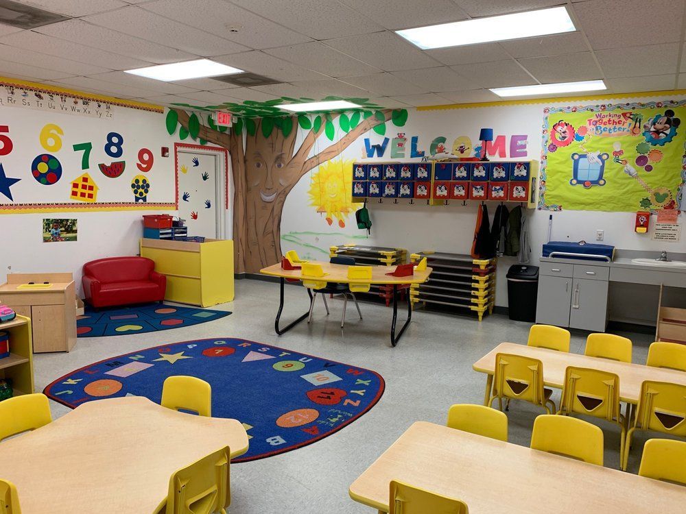 A classroom with tables and chairs and a welcome sign on the wall