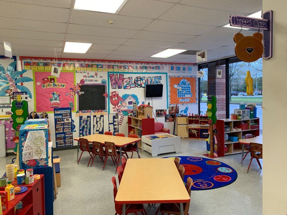 A classroom with tables and chairs and a sign that says welcome