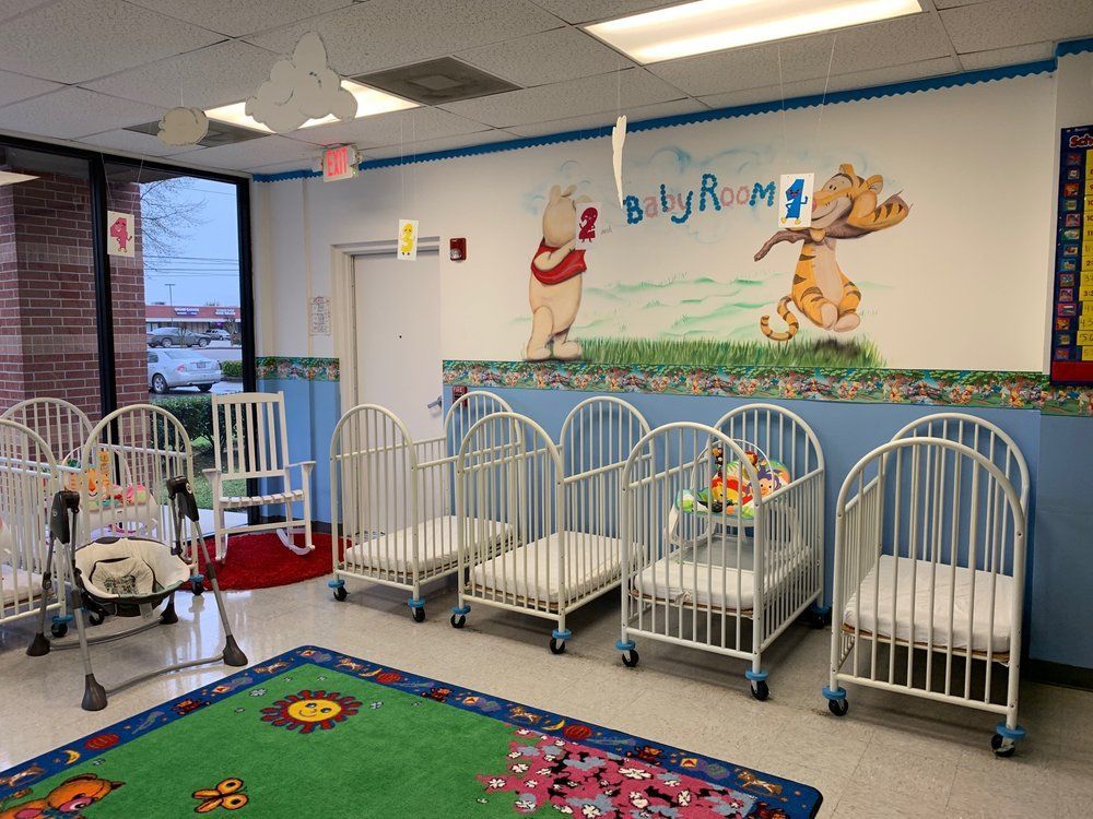 A room with cribs and a mural of winnie the pooh on the wall
