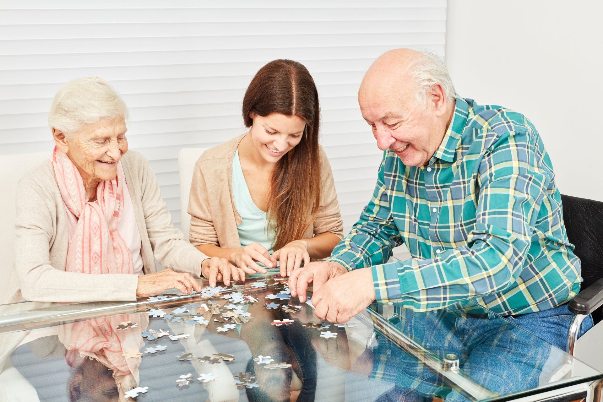 Family with seniors and granddaughter have fun playing puzzle
