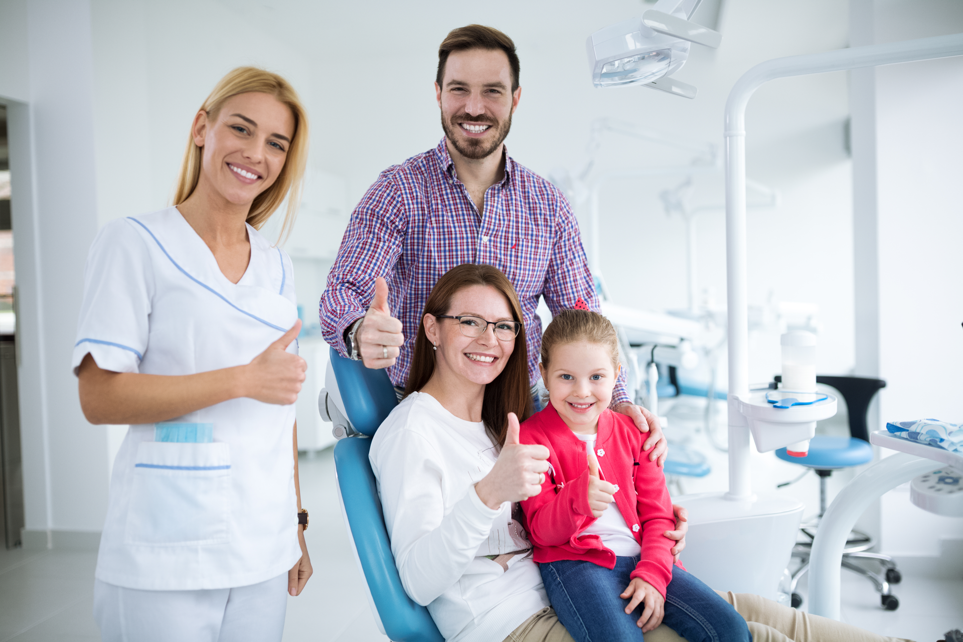 Happy family with a smiling young dentist in a dental office.