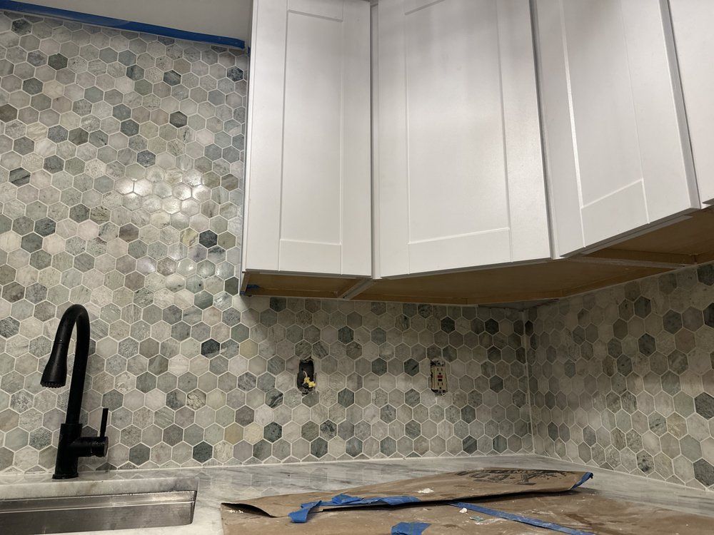 A kitchen under construction with white cabinets and a sink.