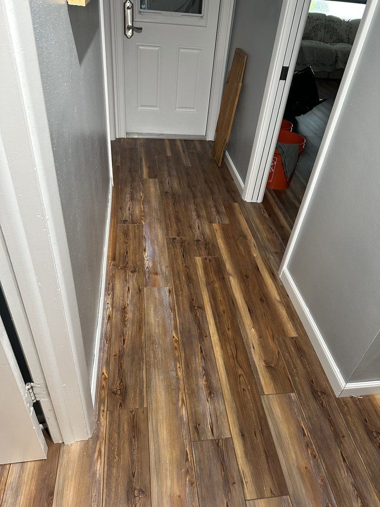 A hallway with hardwood floors and a white door.