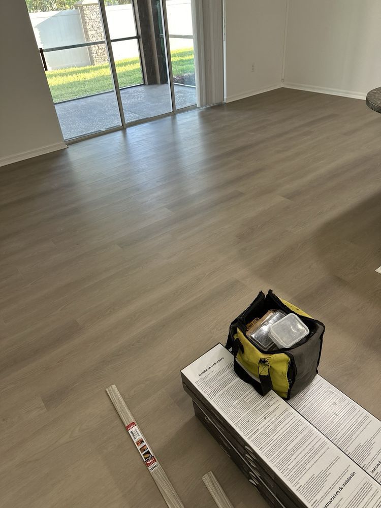 A living room with hardwood floors and a bag on the floor.