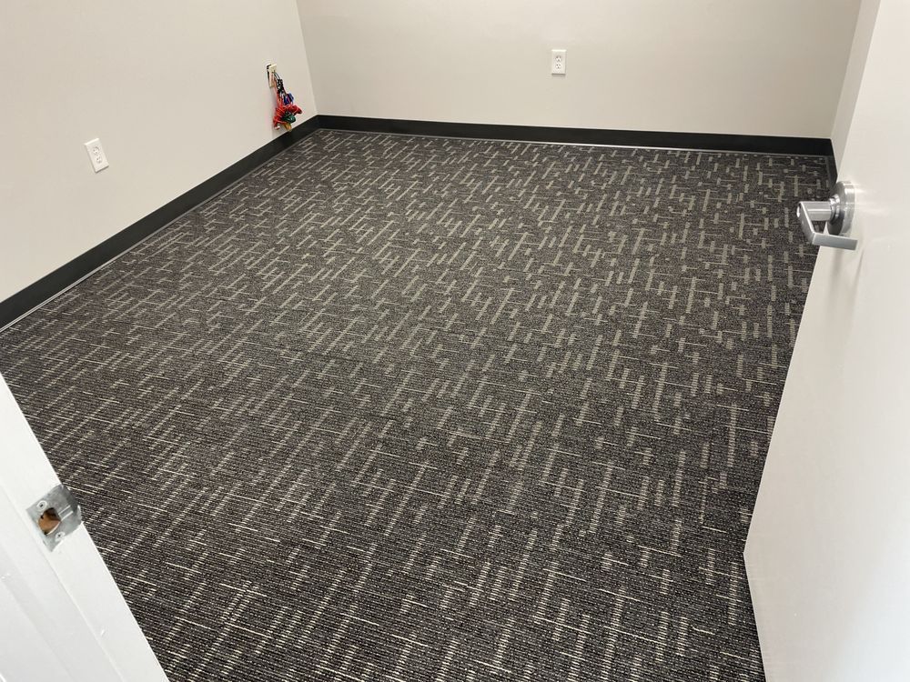 A room with a carpeted floor and a door.