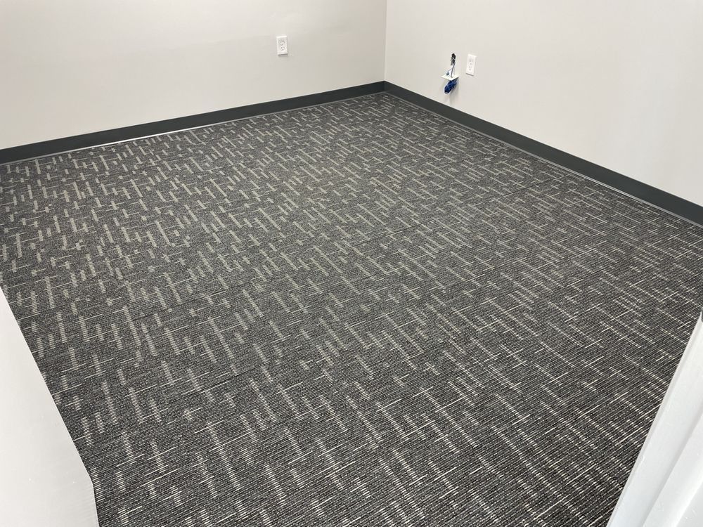 A room with a carpeted floor and a white wall.
