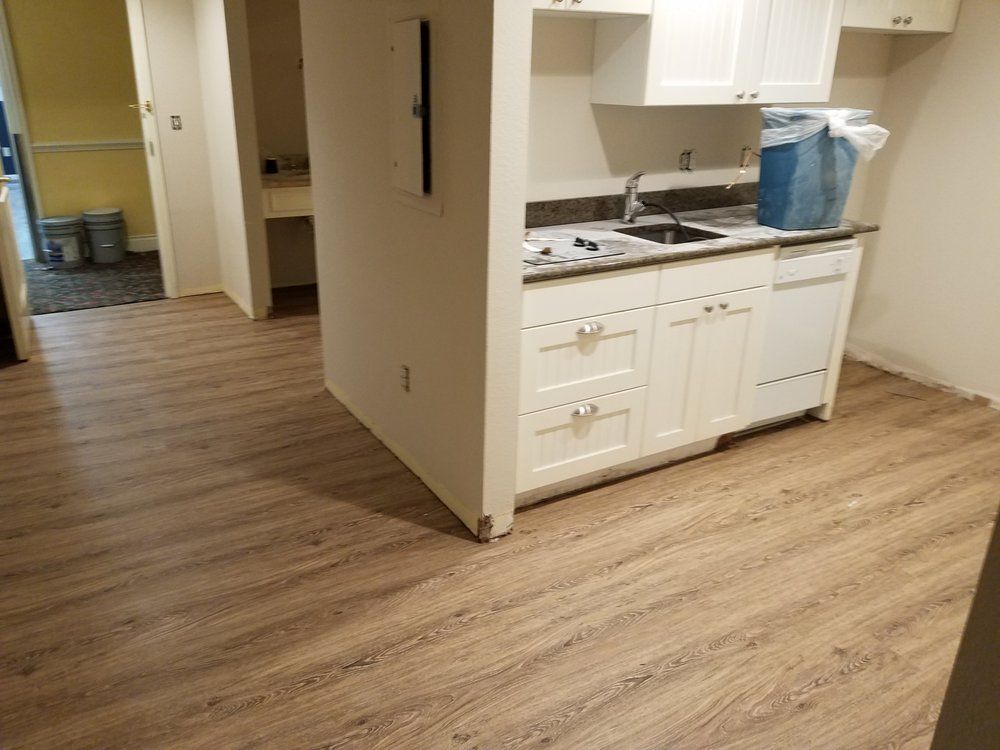 A kitchen with wooden floors and white cabinets