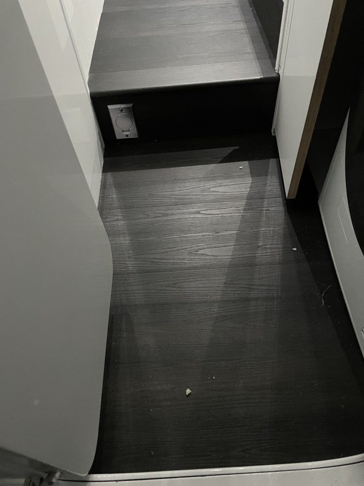A black and white photo of a hallway with a wooden floor.