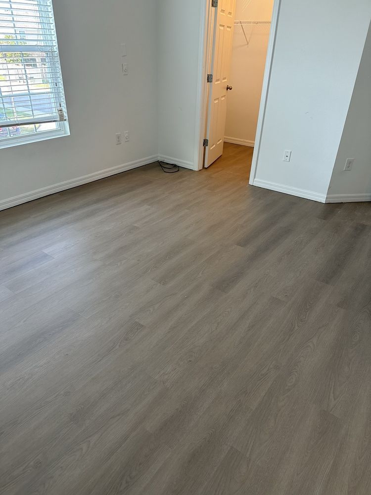 A bedroom with hardwood floors and a window.