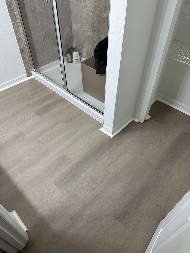 A bathroom with hardwood floors and a walk in shower.