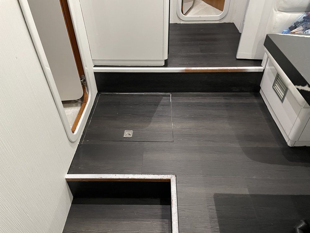 A bathroom with stairs leading up to a sink and a mirror