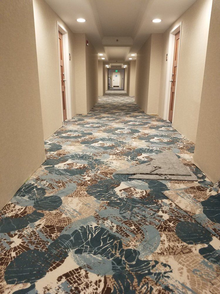 A long hallway in a hotel with a patterned carpet.