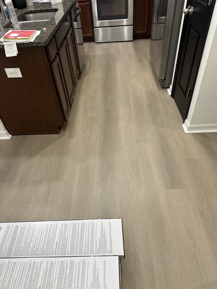 A kitchen with hardwood floors and stainless steel appliances.