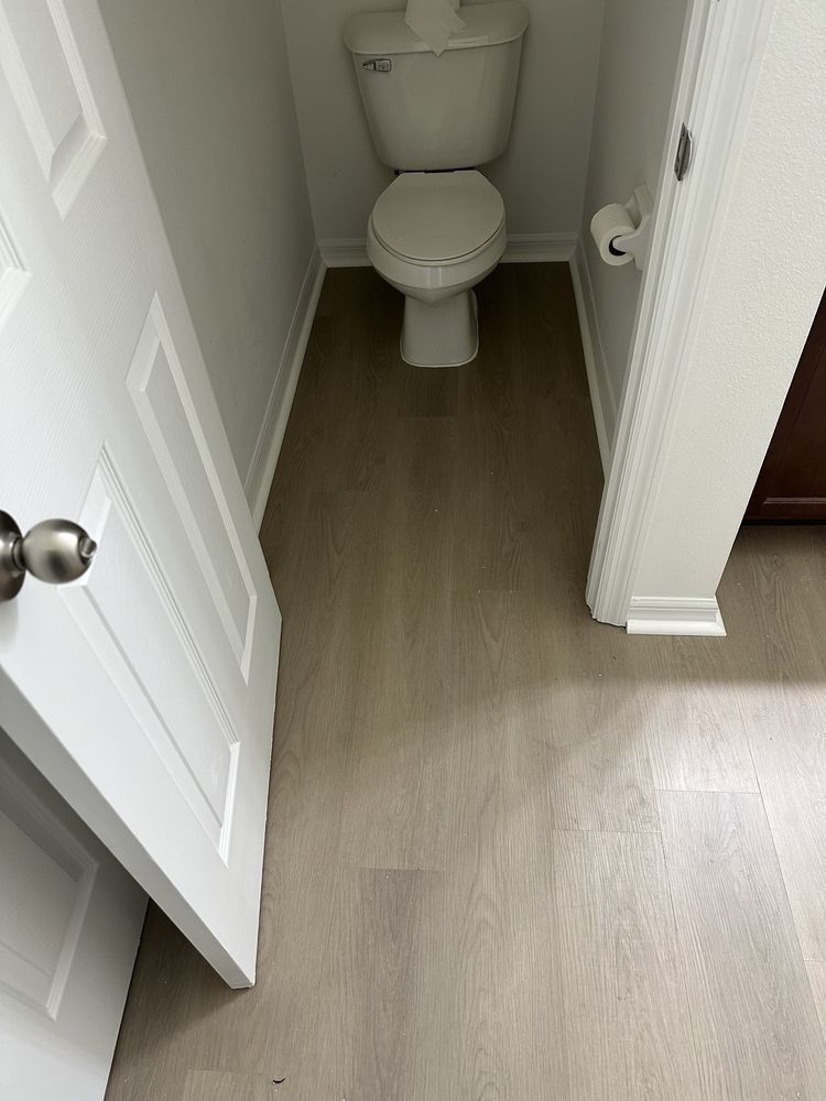 A toilet is sitting in a small bathroom next to a door.