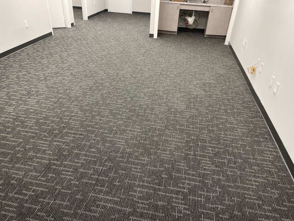 A room with a carpeted floor and a sink in it.