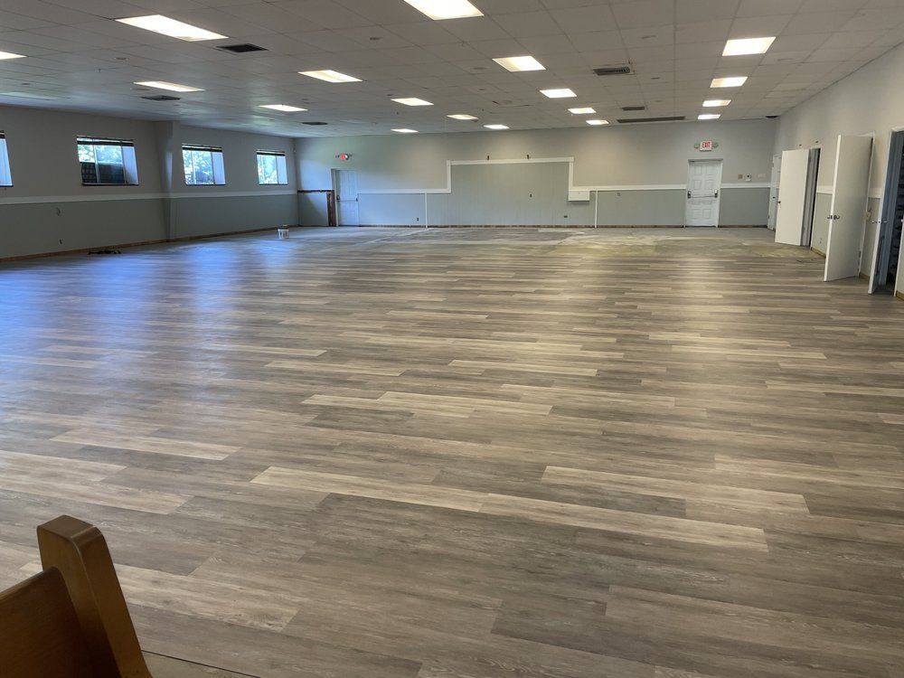 A large room with a wooden floor and white walls