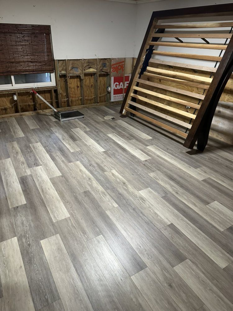 A room with a wooden floor and a bed in it.