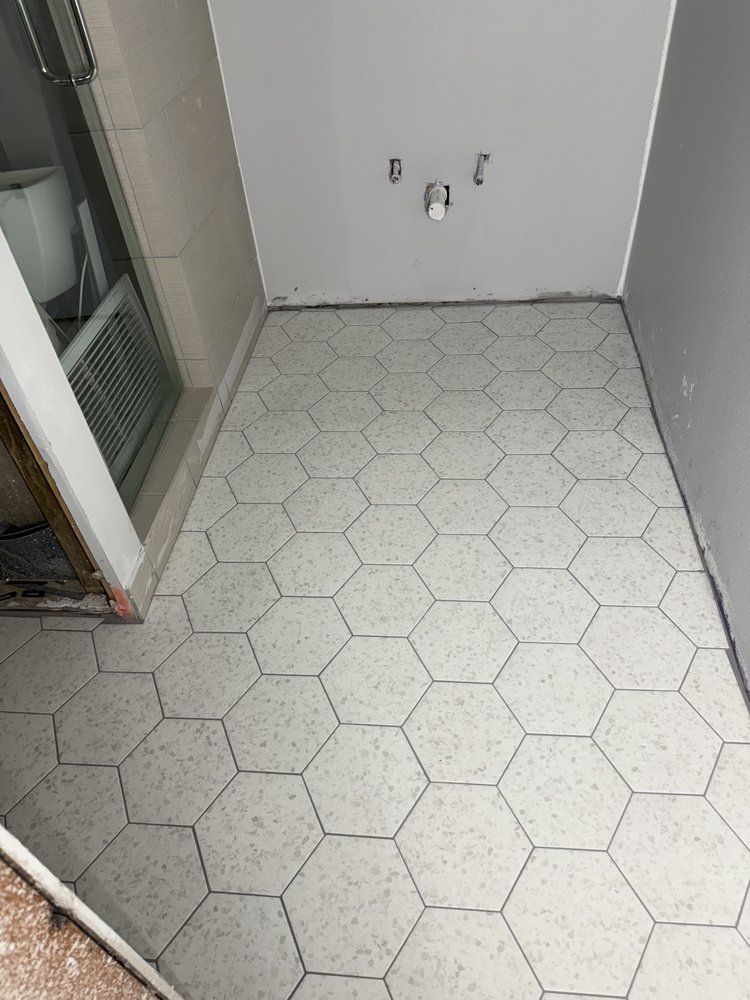 A bathroom with hexagonal tiles on the floor.