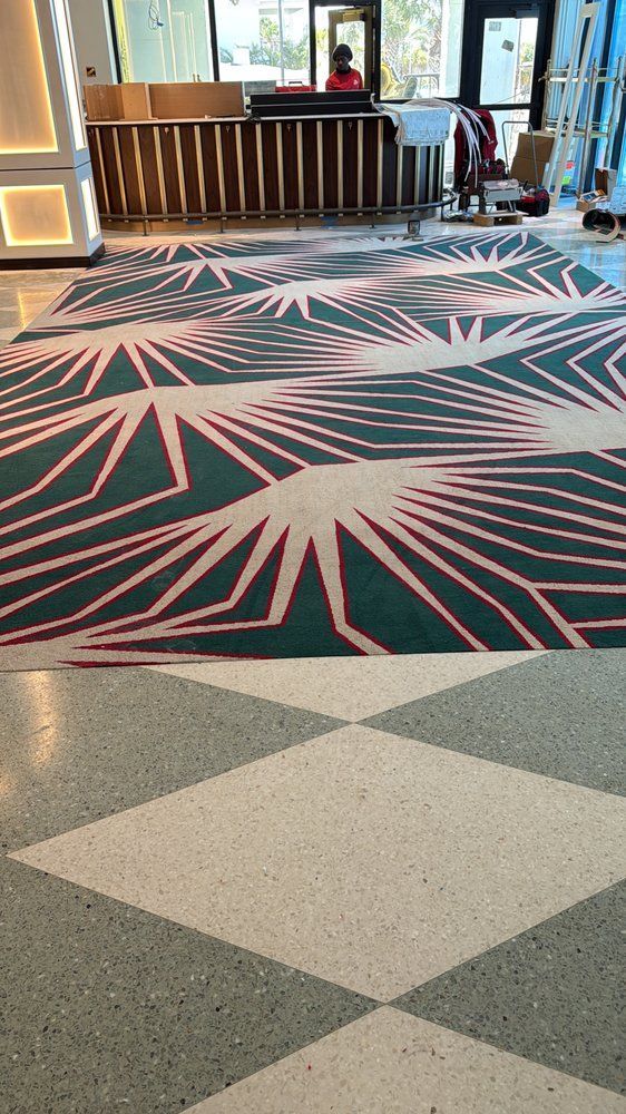 A hotel lobby with a checkered rug on the floor.