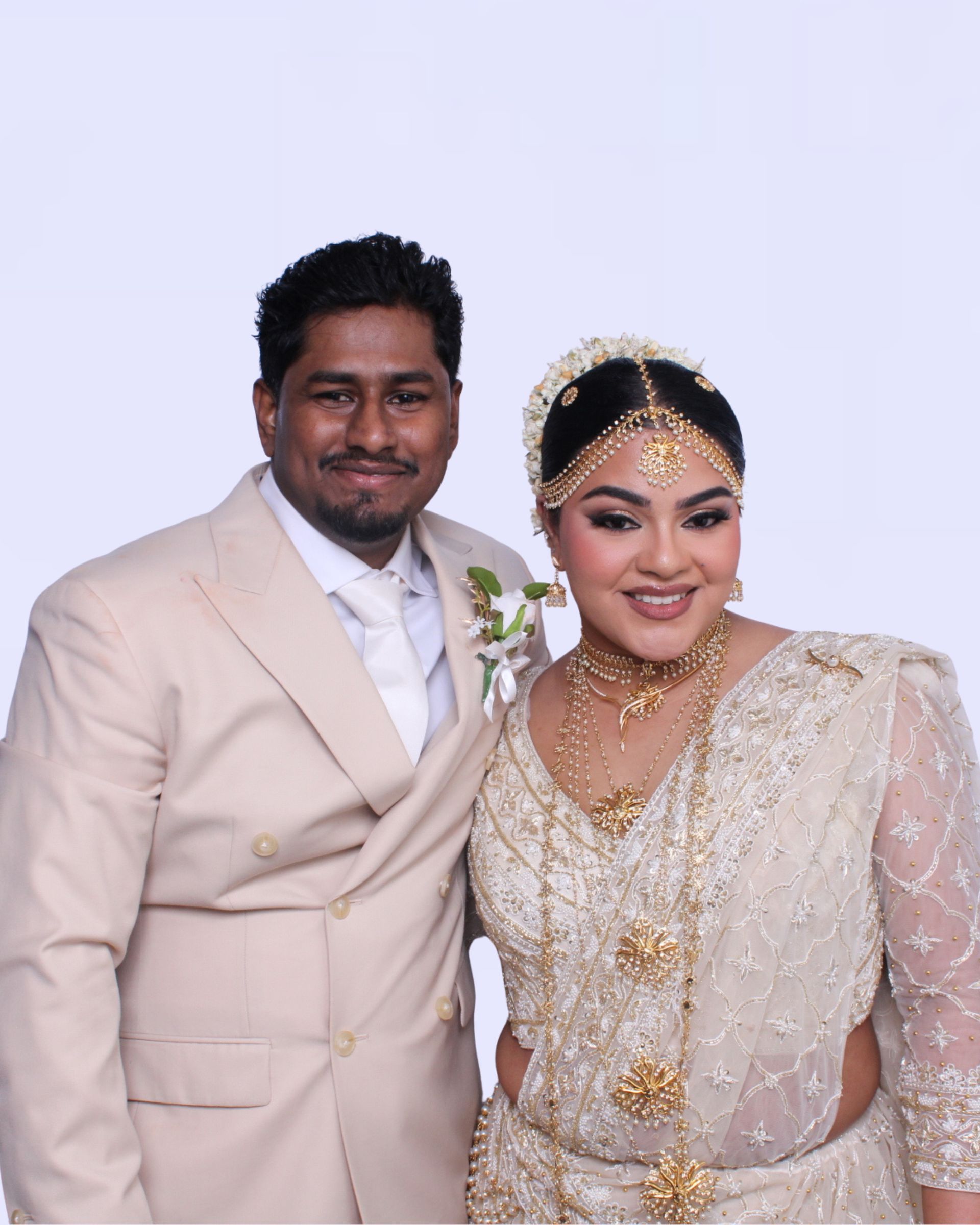 Poruwa ceremony, ritual of a traditional Sri Lankan wedding. Man in light suit and woman in white sari, smiling. Formal wedding photo booth.