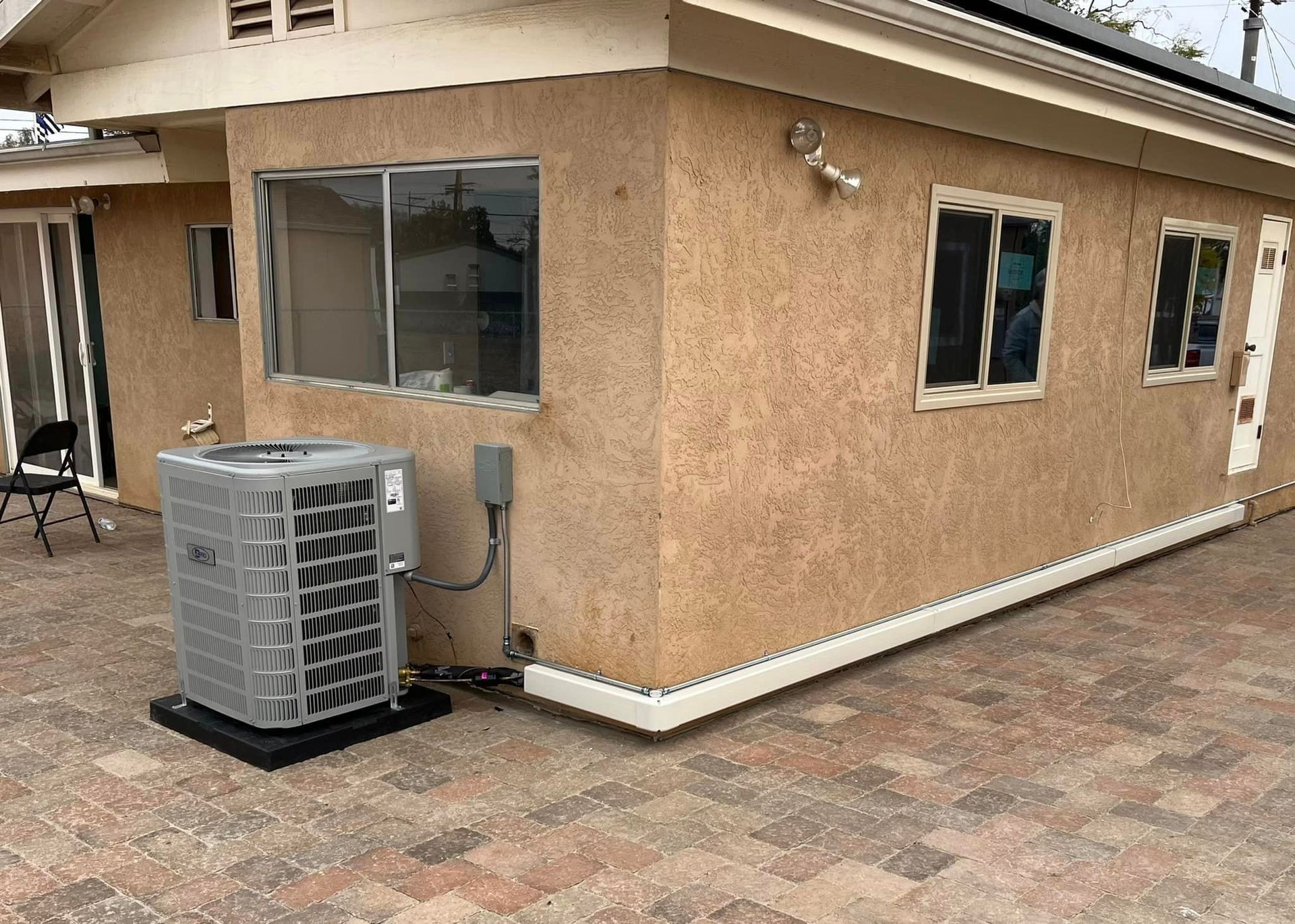 A house with a air conditioner on the side of it.