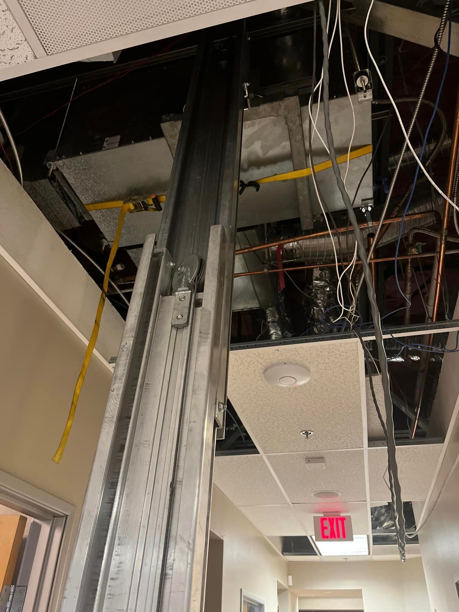 A hallway with a red exit sign on the ceiling