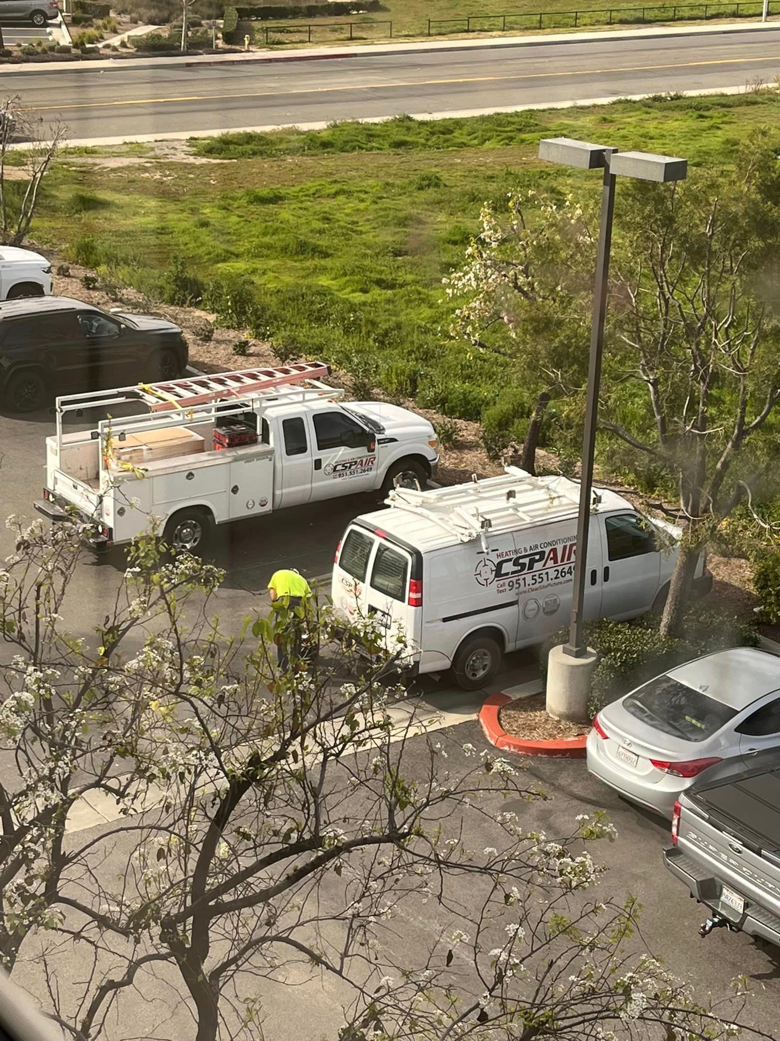 A bunch of trucks and vans are parked in a parking lot.