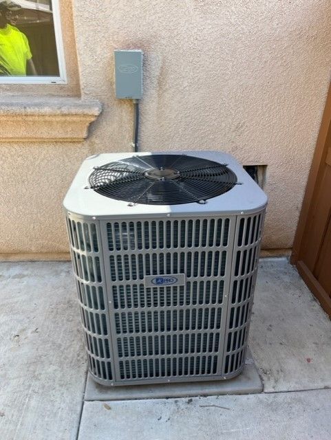 An air conditioner is sitting on the sidewalk outside of a building