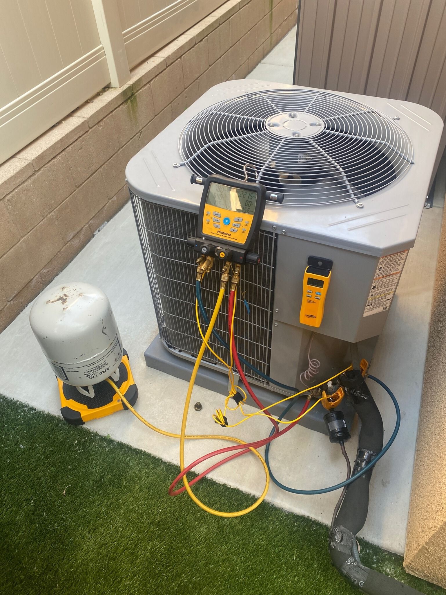 An air conditioner is being repaired on the side of a building.