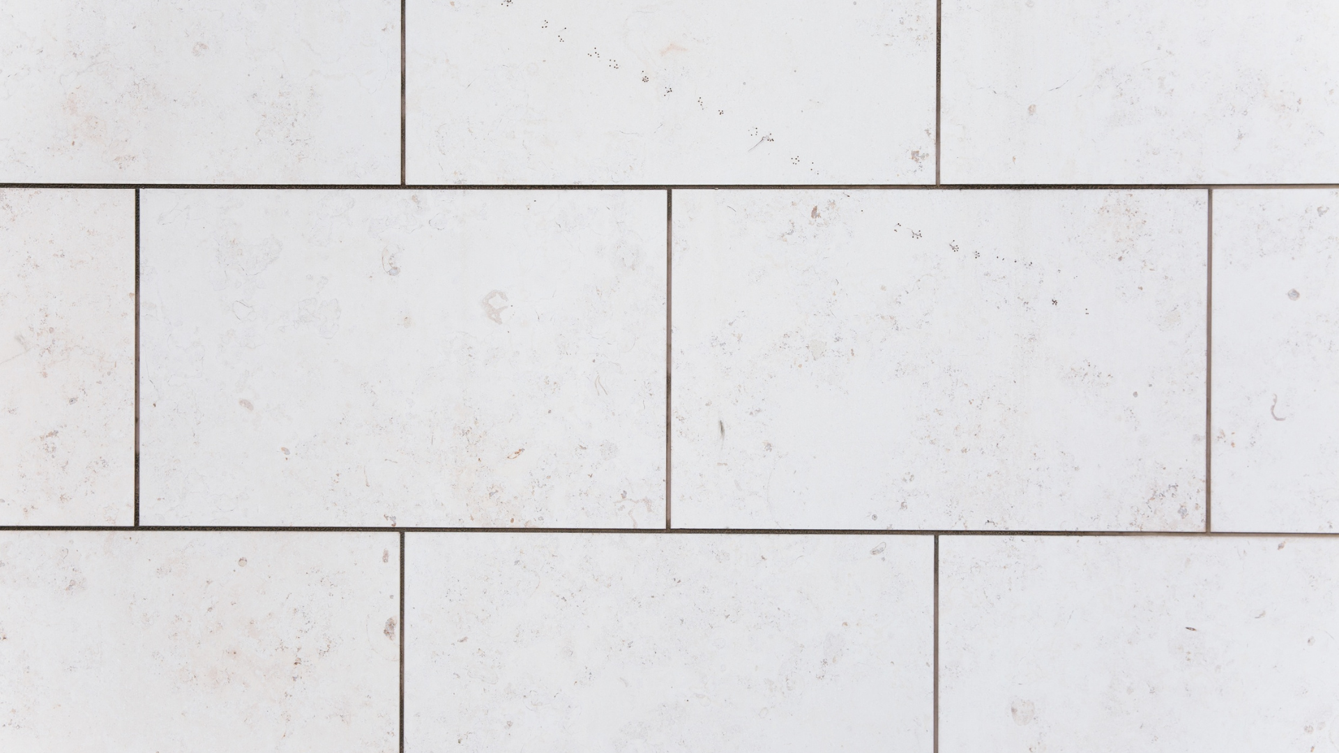 White brick wall with rectangular blocks and visible grout lines.