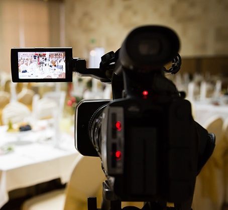 A video camera is taking a picture of a room with tables and chairs