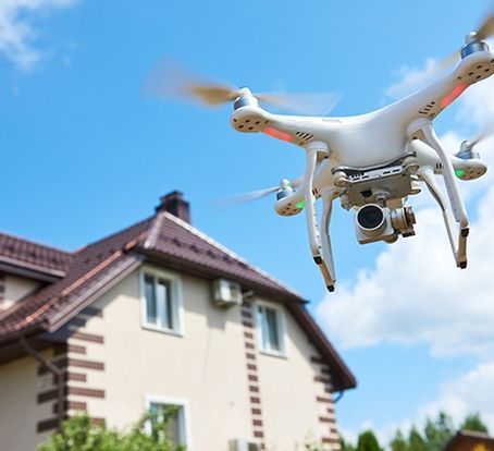 A drone with a camera is flying over a house