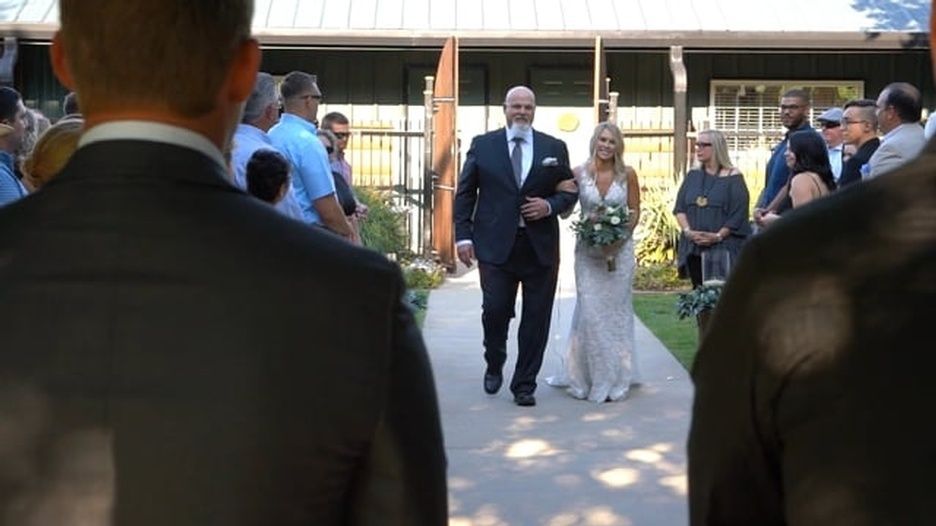 A bride and groom are walking down the aisle at a wedding