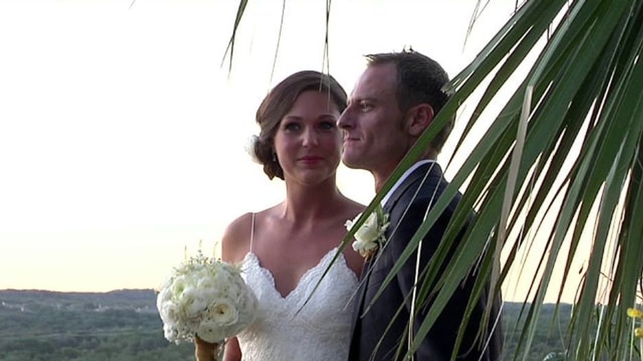 A bride and groom are posing for a picture in front of a palm tree